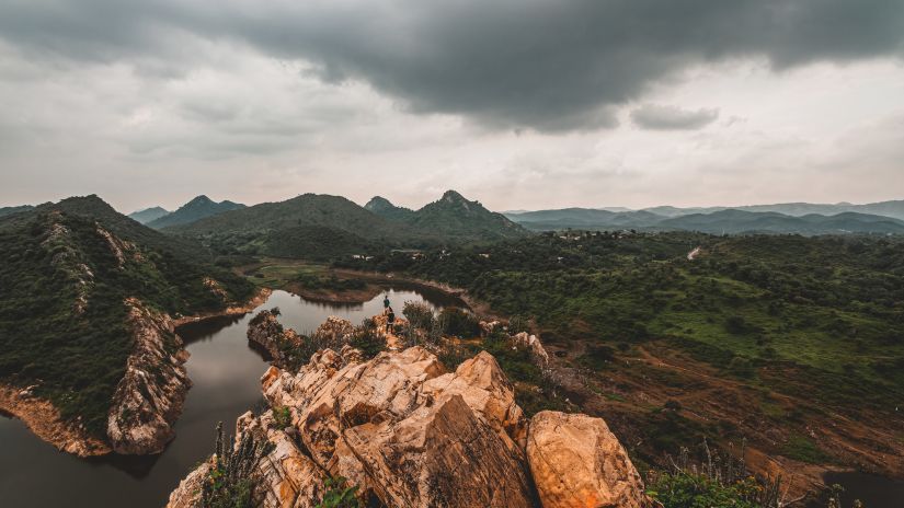 Nature with a small steam running on the left and greenery and hills in the background