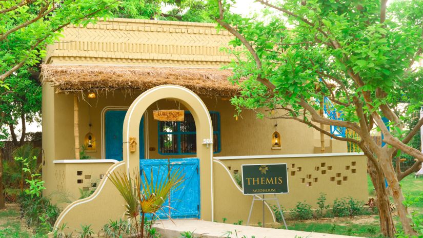 Facade of a pool villa at Themis Mudhouse, a nature resort near Delhi