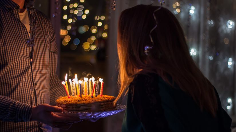 person blowing out candles on a cake