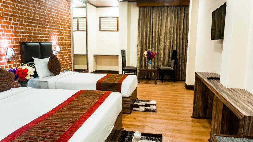 Premium room at Tin Tin Boutique Hotel with twin beds and a television