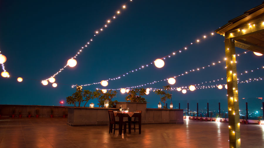 The rooftop decorated with lights and a sitting area to host dining under the stars