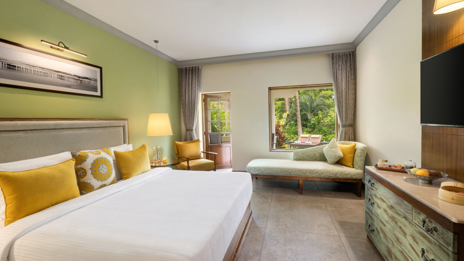 room with king size bed and modern mint green interiors at Heritage Village Resorts and spa in goa