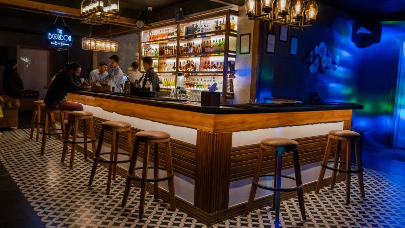 Well-lit bar counter in The Bourbon Club N Lounge at The Tattva Boutique Resort, Joshimath