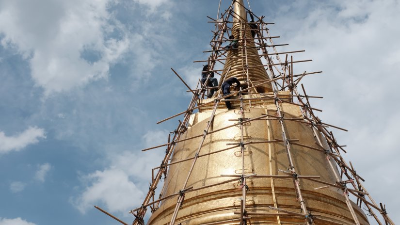 A temple being constructed with bamboos around for stability