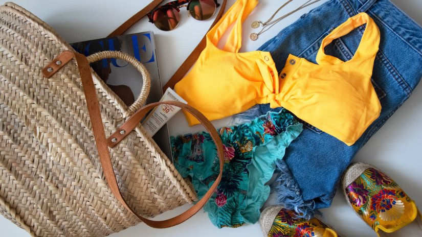 a bag with beach attire sunscreen and shades