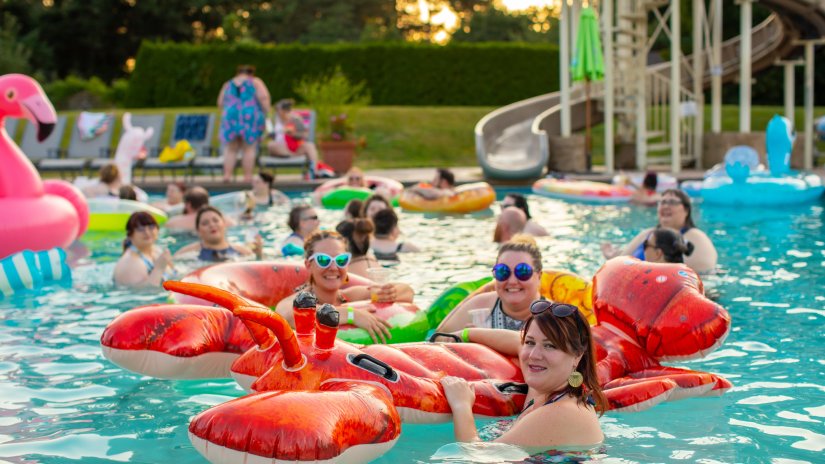 People swimming in the pool with inflated toys