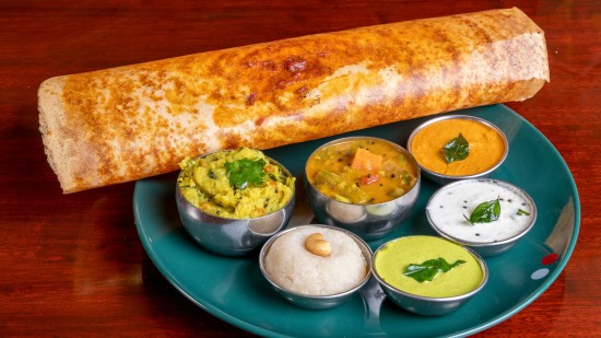 A Dosa platter with many side items kept on a plate