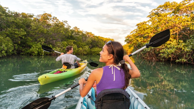 a man and a woman kayaking on a river during daytime