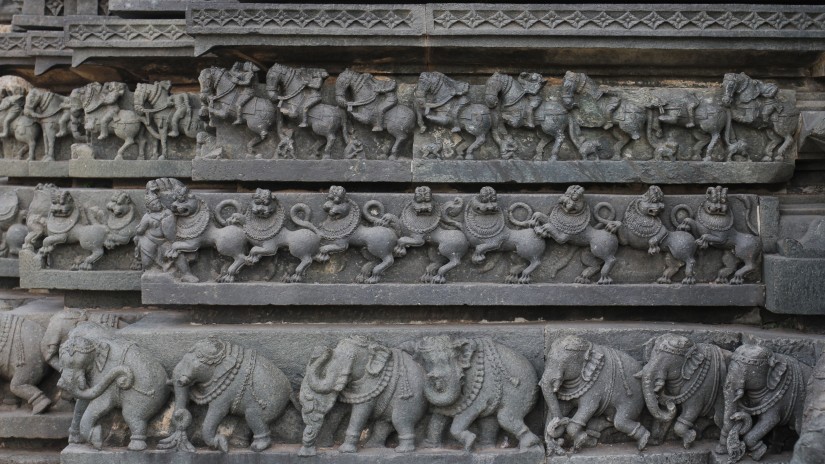 Image of a series of stone sculptures depicting lions elephants and a cavalry of soldiers mounted on horses