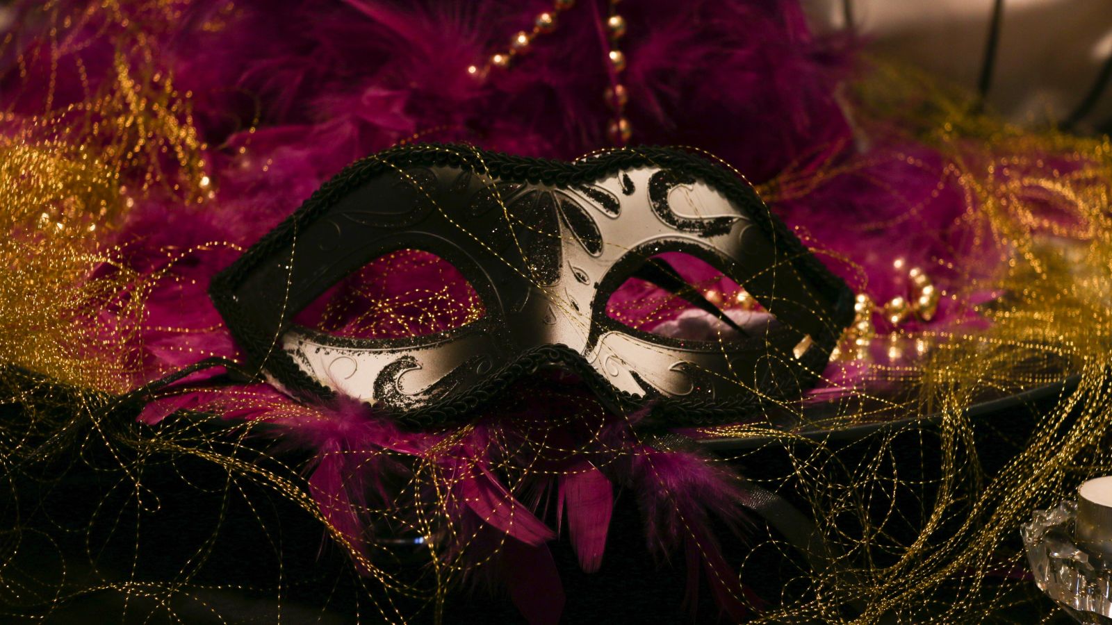 A masquerade mask showcased with decorations on the sides