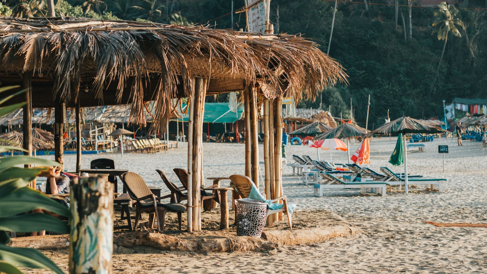 a beach shack at a beach in Goa with flags in the background