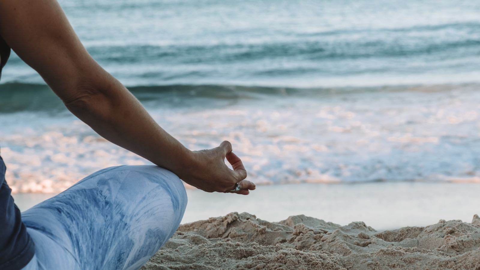 A woman meditating near the serene beach