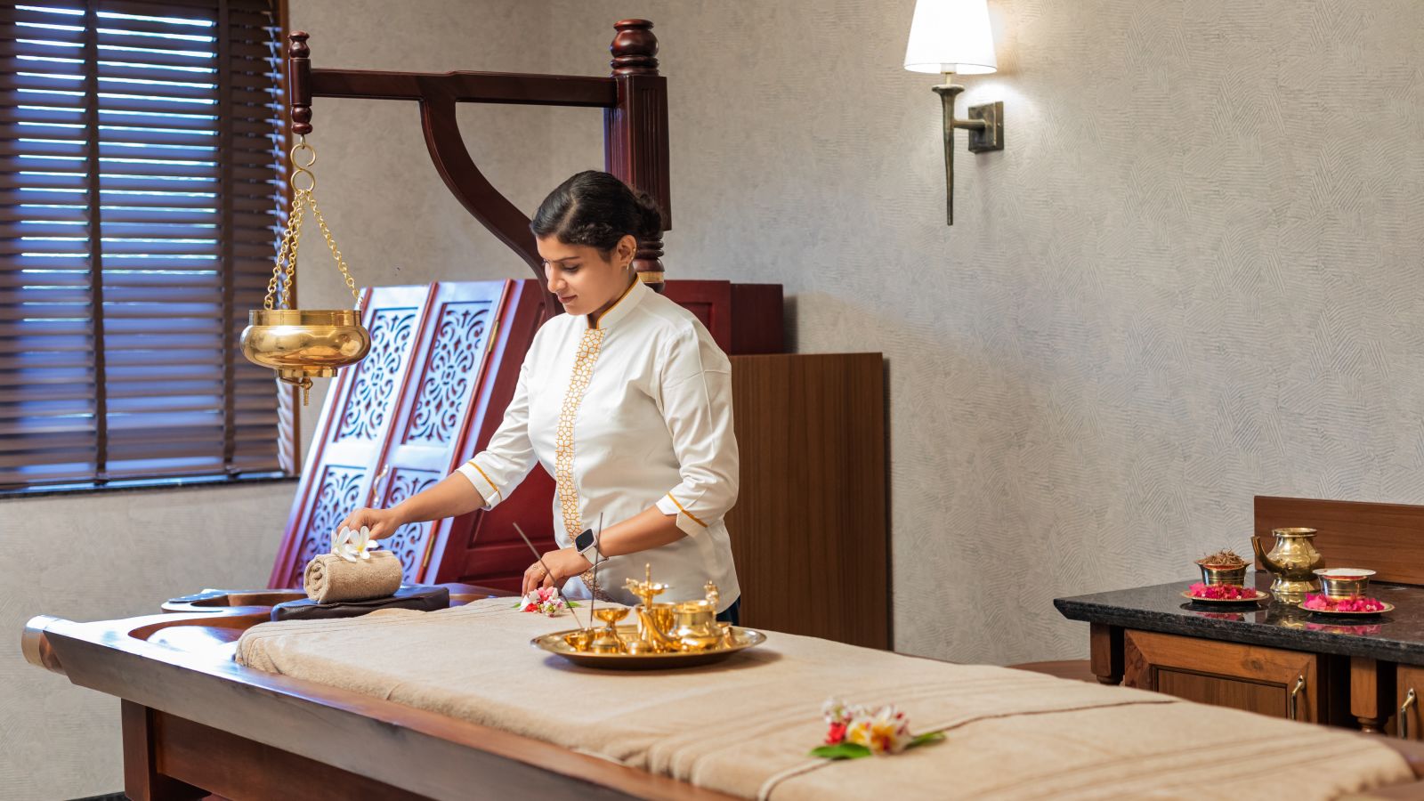 a massage therapist preparing a spa room for a therapy session