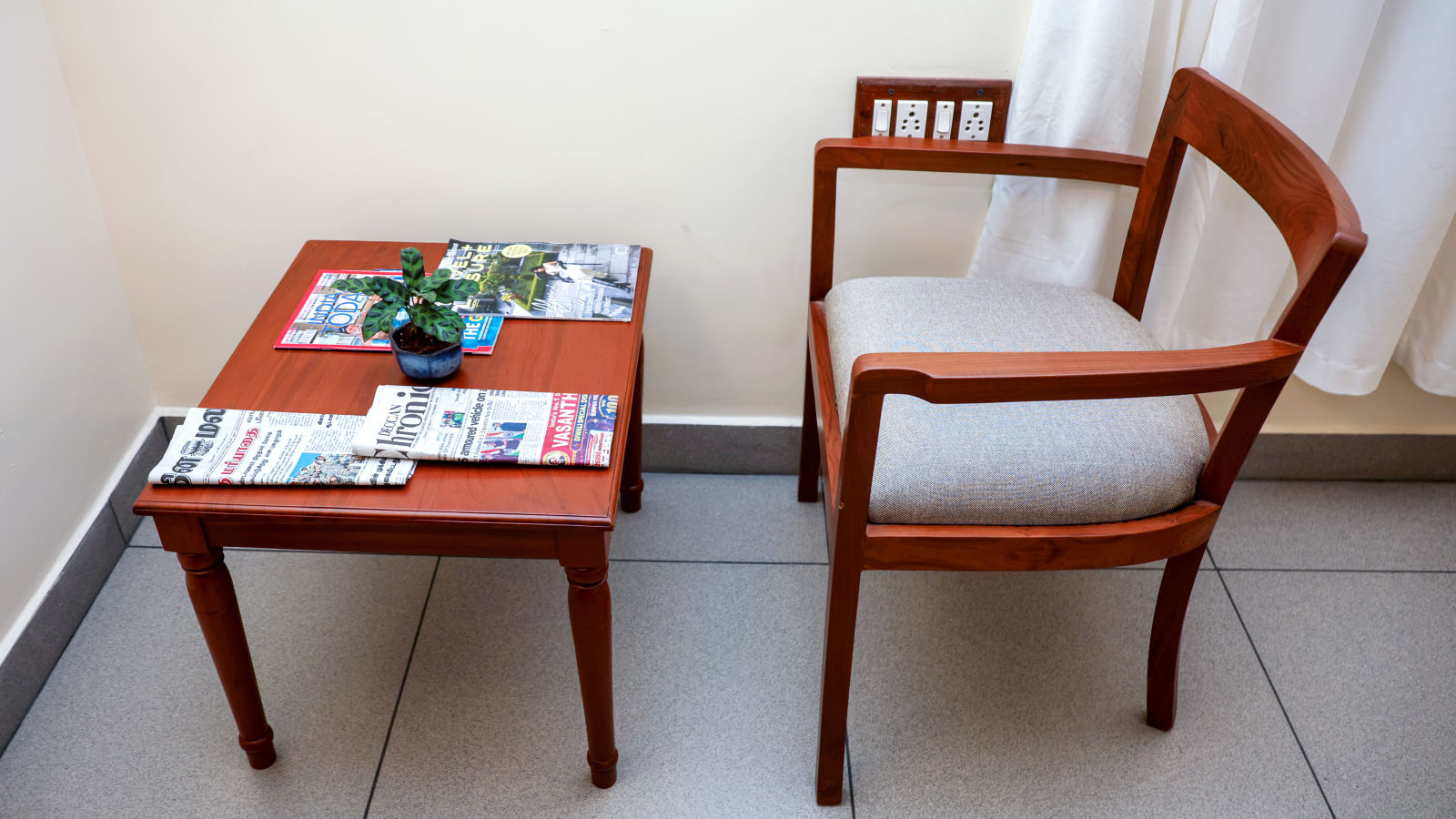 A table and a chair placed at one corne of a room | Mango HIll La Serene, Ponicherry