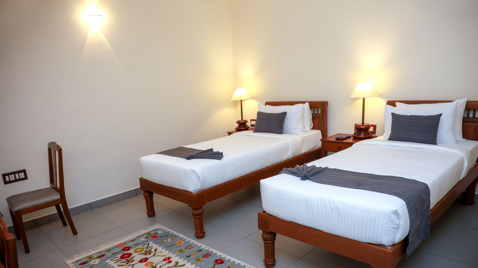 Twin beds and a chair in a room  | Mango HIll La Serene, Ponicherry