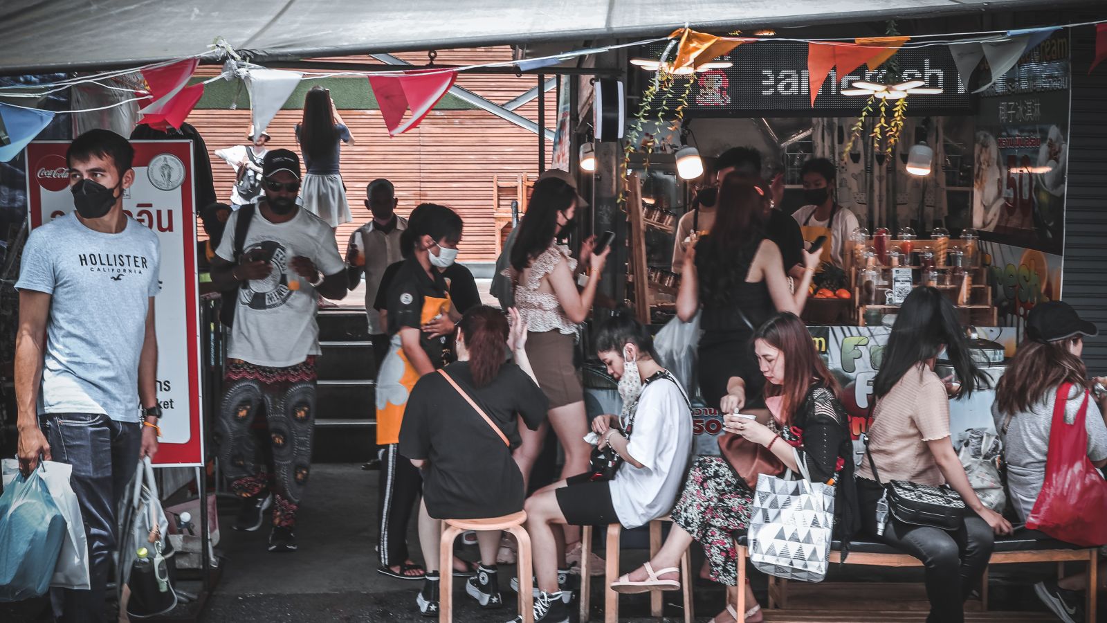 Many people sitting in the Chatuchak Weekend Market having street food