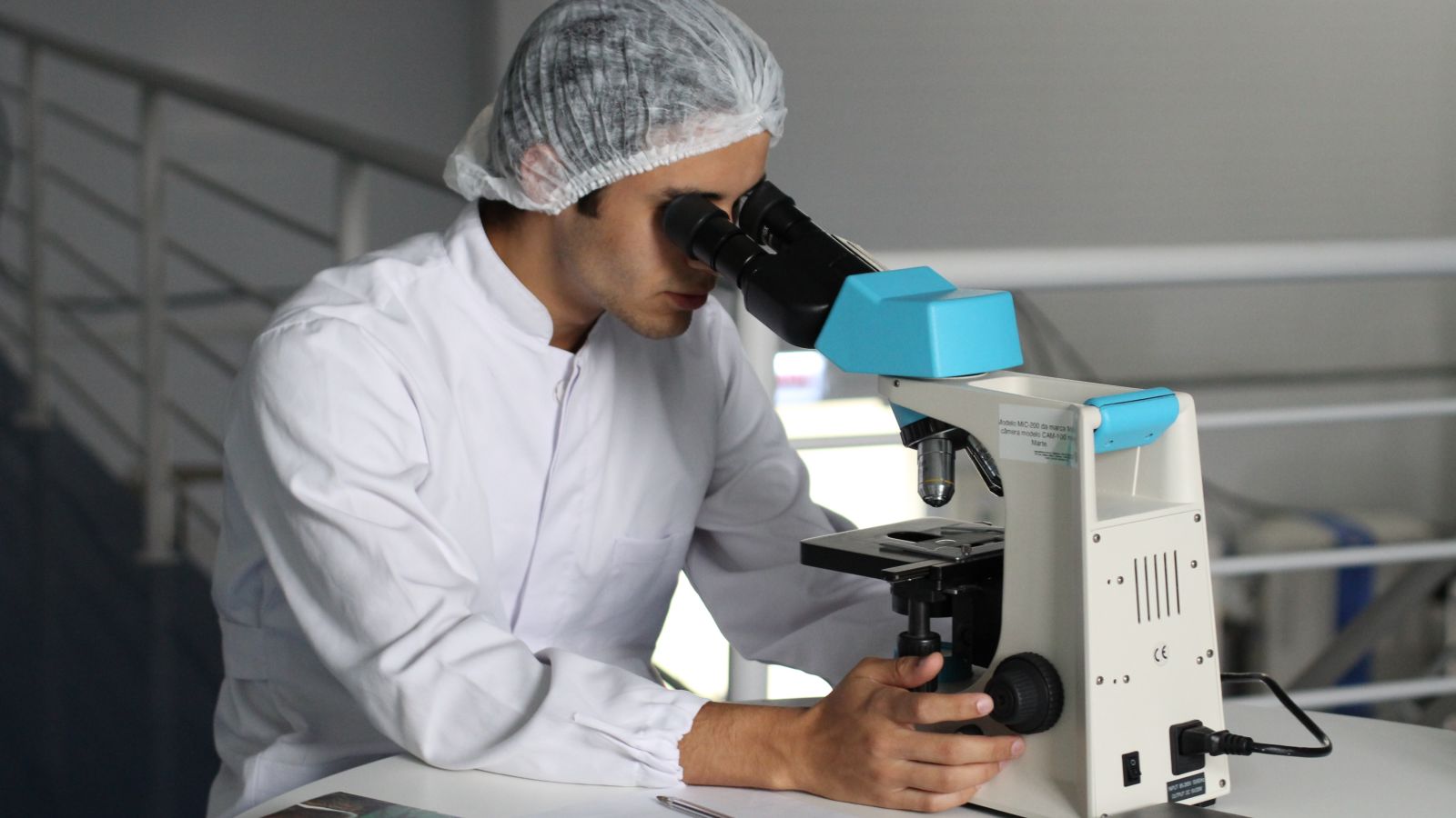 a person looking into a microscope in a laboratory