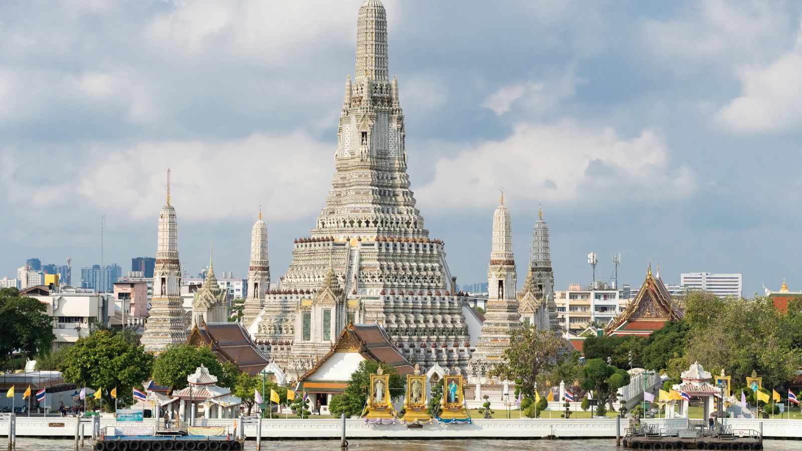 Facade image of Wat Arun with white clouds on blue sky in the background