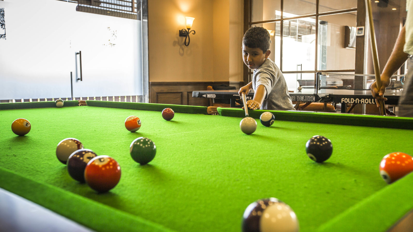 Kid playing pool ball