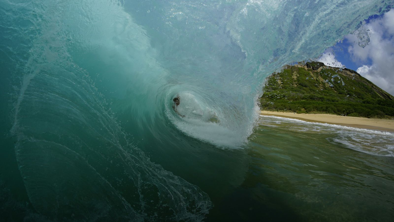 An image of a wave and a man doing body surfing 