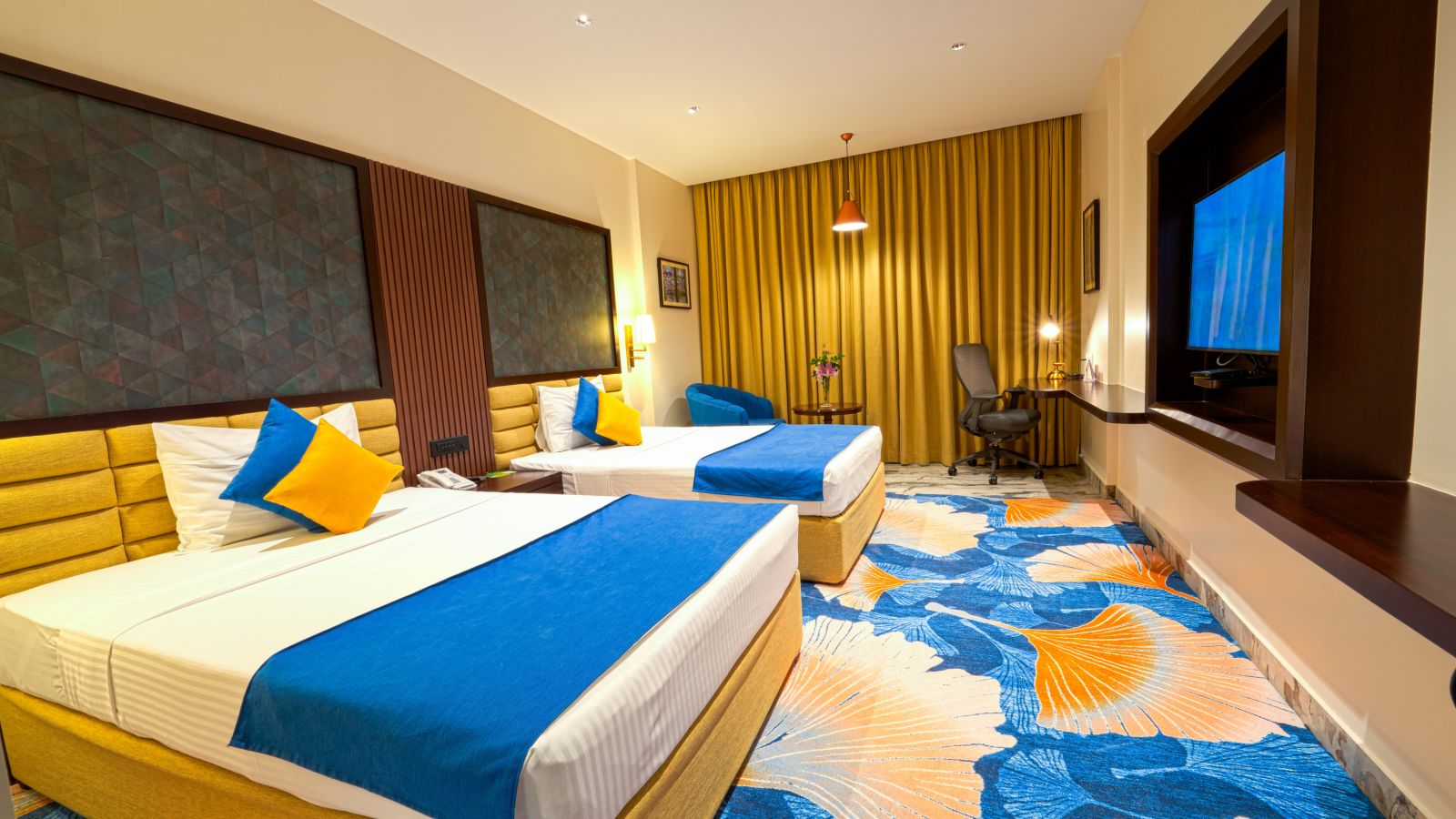 Room at Sitara Luxury Hotel with twin beds and a television