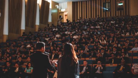 Speakers addressing a large audience at a conference