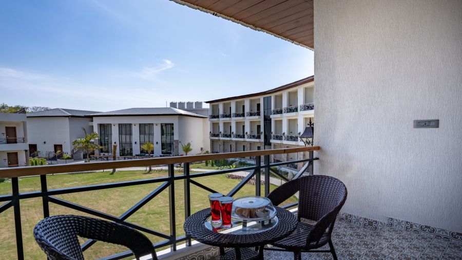 A balcony in the superior room with comfortable chairs placed around a coffee table - Shervani Pebbles & Pines, Corbett