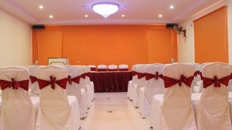 Hotel Yasodha Towers - interior view of a mini party hall in hosur featuring chairs decorated with satin cloth and lined in 4 columns