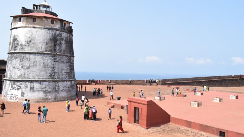 A wide shot of Fort Aguada shows people walking around it