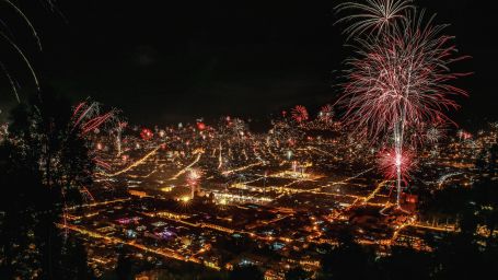 An aerial view of fireworks in a well-lit city at night | New year in Odisha