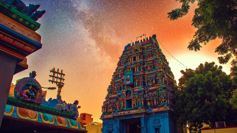 Image of a hindu temple decorated with vibrant colours during daytime