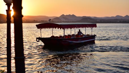 A lonely boat in the lake with sunset in the background- Udaipur 