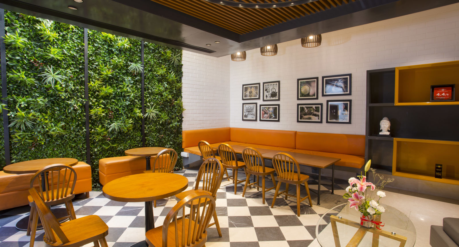 a room with large windows with views of trees and circular tables with chairs around them - Hotel Fountain Tree By TGI - JP Nagar, Bangalore