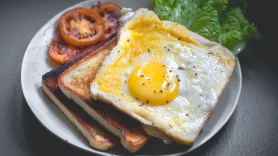 a plate served with  bread, omelette and salad