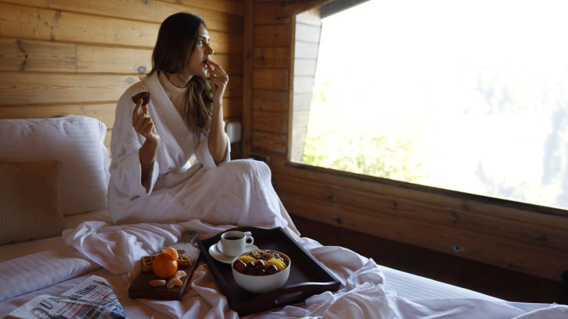 guest eating on the bed of the presidential villa 5 - Polo Orchid Resort, Cherrapunji