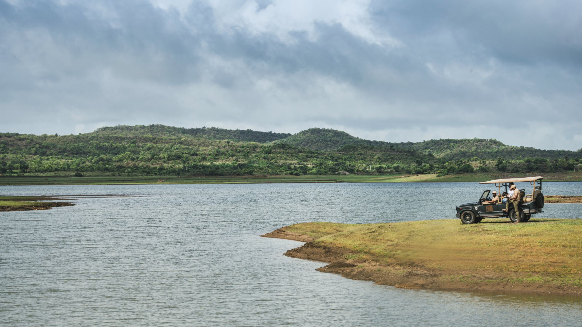 a safari jeep parked at a lake in Gir