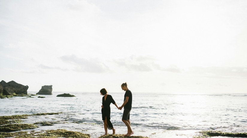 A couple taking a leisure walk on the shore of a beach