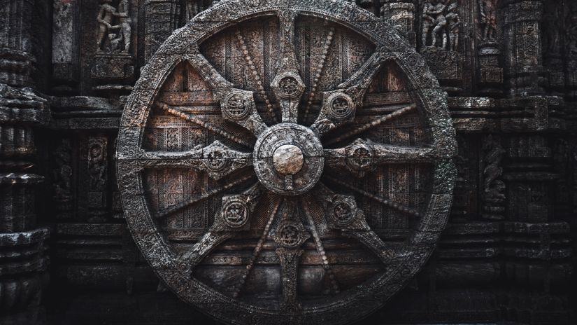 A wheel is craved on a stone with details.