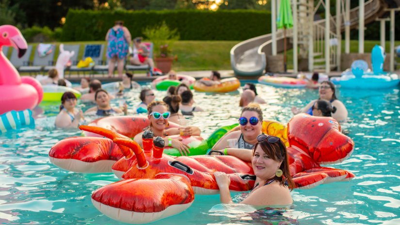 People swimming in the pool with inflated toys