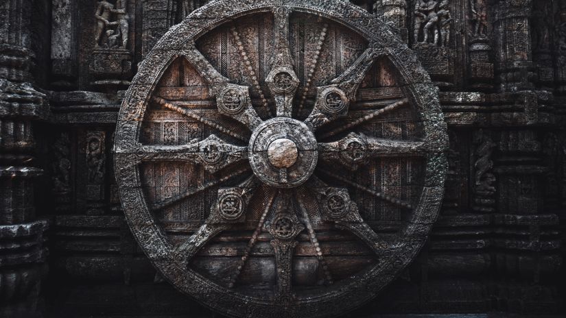 A wheel is craved on a stone with details.