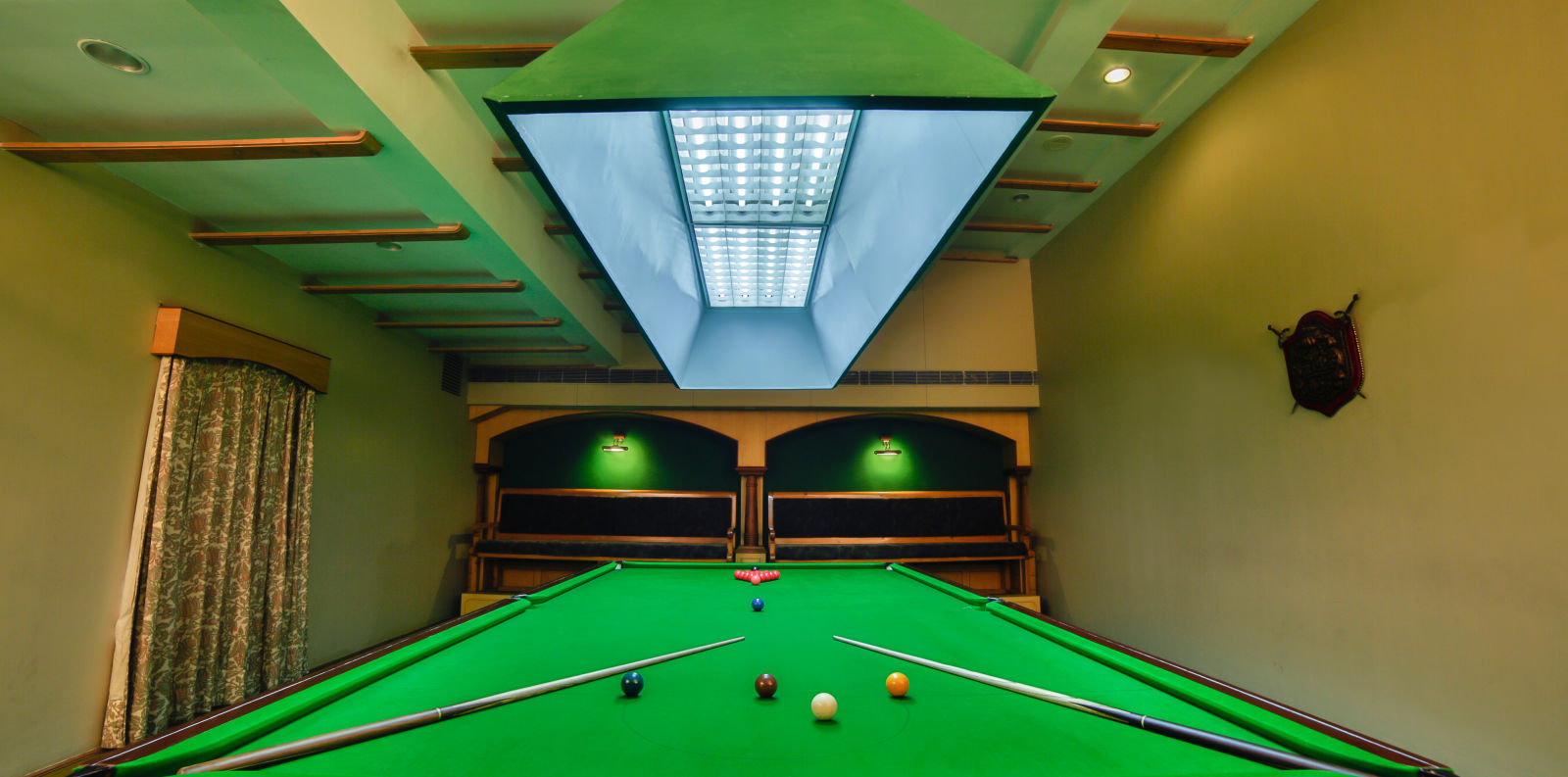 pool table with billiards cue sticks placed at the corners at Hotel Tara, Hyderabad