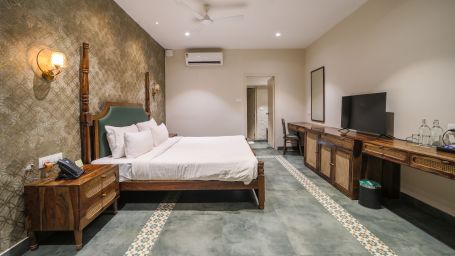 An image of a room with king size bed, TV, bed side table - Trance Veechika Resort, Vikarabad