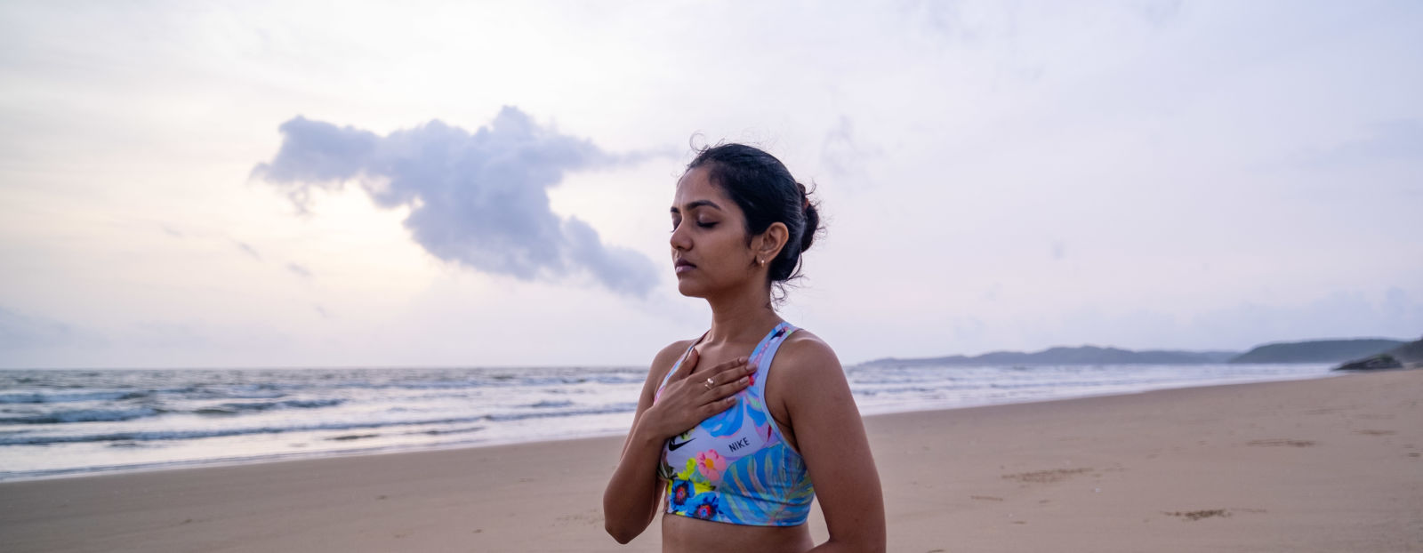 a person practising yoga at the beach