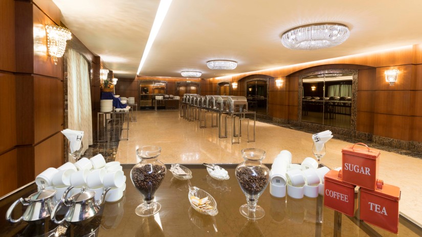 Glasses and plates arranged in a banquet hall at Hablis Hotel, Chennai 