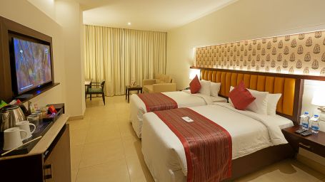 Deluxe room at Grand Continent, Secunderabad with twin beds and a television