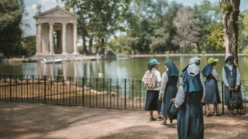 A group of nuns standing in front of a historical building 