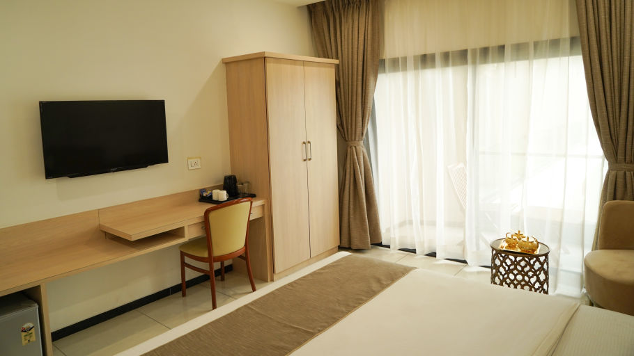 Pride Ranakpur Resort Convention Centre - interior view of the super deluxe room showcasing a king size bed a wardrobe and a television