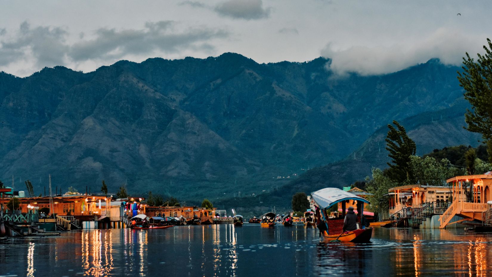 an overview of a lake in udaipur with a mountain and evening sky in the background