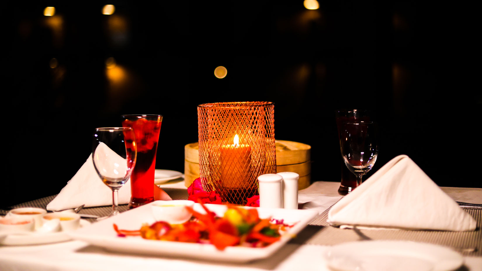 A close-up shot of a candlelight dinner set up underneath the stars