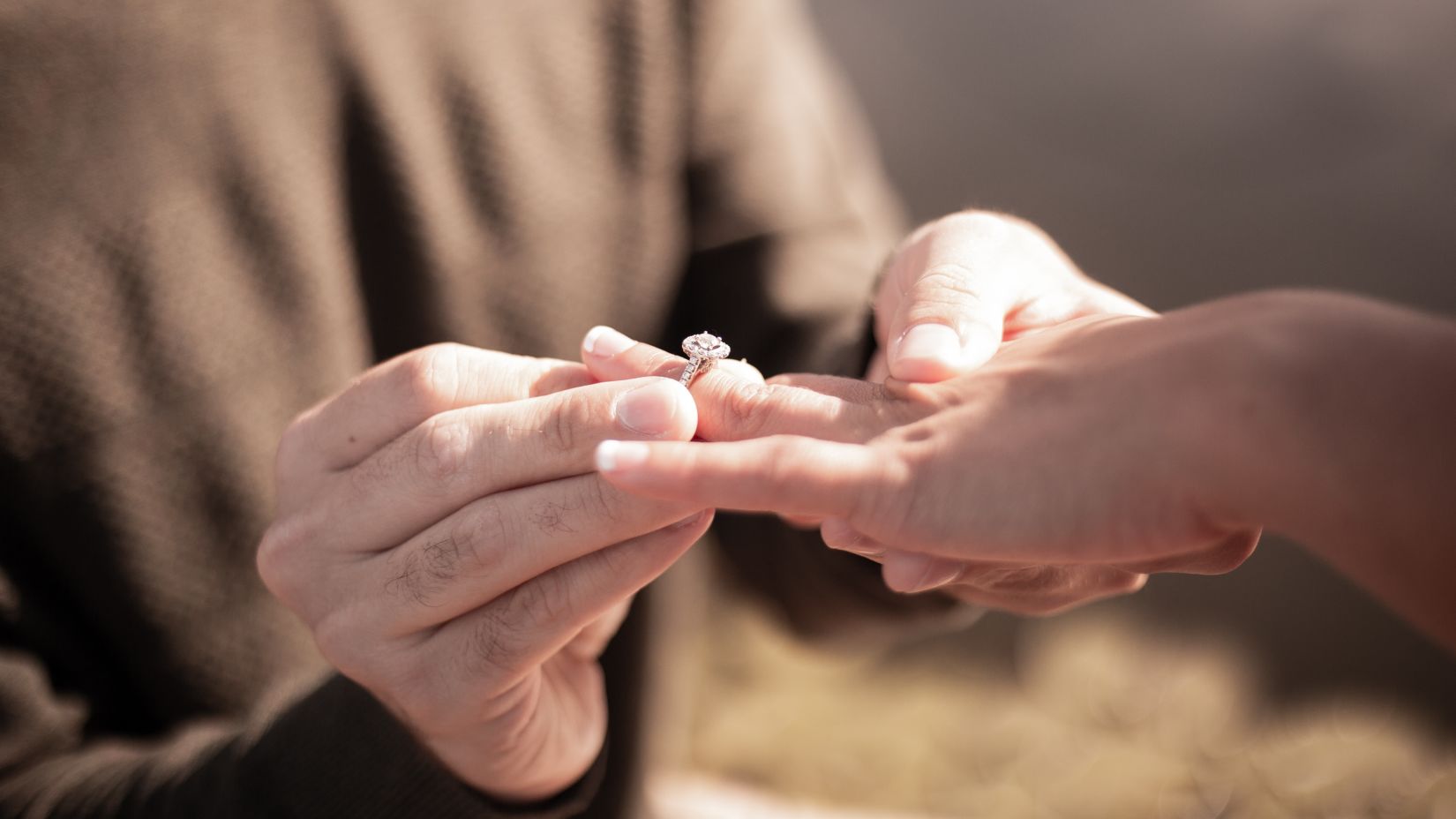 a man putting a ring on a woman